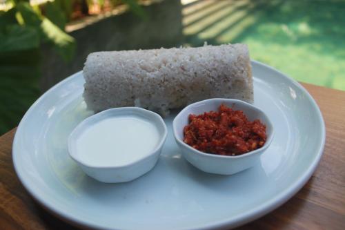 a plate with a piece of bread and a bowl of salsa at Aryana Boutique Hotel in Anuradhapura