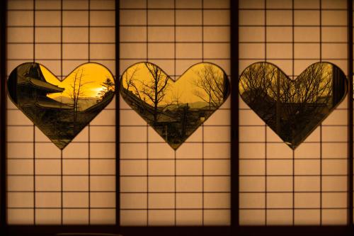 a group of hearts on a window with the sunset at Yamadaya Ryokan in Kyoto