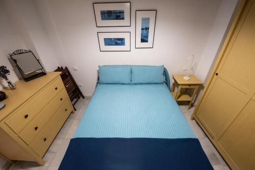 a small bedroom with a blue bed in a room at Alfareria Ocho in Seville