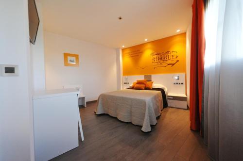 een slaapkamer met een bed en een gele muur bij Rincón del Nazareno in Almazán