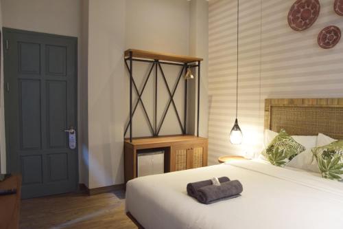 a bedroom with a large white bed and a black door at Grhatama Guest House in Yogyakarta
