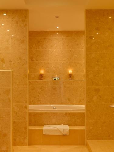 a bathroom with a shower with a tub and a sink at Diamond Coast Hotel in Enniscrone