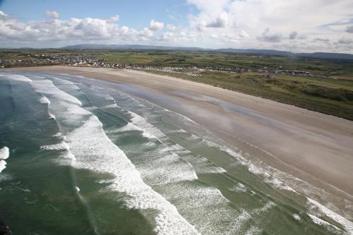 an aerial view of a beach with waves at Diamond Coast Hotel in Enniscrone