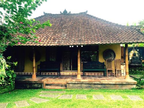 a small house with a bench in a yard at Bali Mountain Retreat in Selemadeg