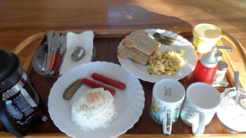 a tray with two plates of food on a table at Haus am Strand KLIMAANLAGE INKLUSIVE Sibuyan Island nahe Cresta de Gallo - Marevic's Guesthouse 1 in San Fernando