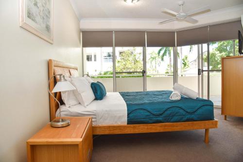 a bedroom with a bed and a window at Founda Gardens Apartments in Brisbane