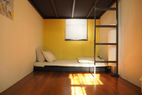 a room with a bed in a room with a window at Yu Cafe Hostel in Songkhla