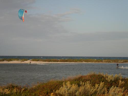a person flying a kite over a body of water at Agriturismo Ezzi Mannu in Stintino
