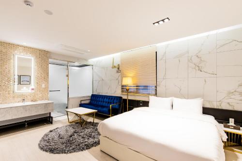 釜山にあるAir Sky Hotelのベッド、バスタブ、バスルームが備わるホテルルームです。