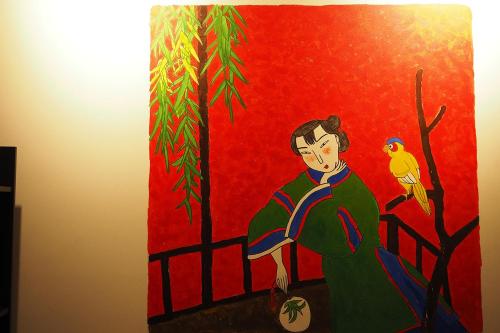 a painting of a woman with a bird on a fence at Yu Cafe Hostel in Songkhla