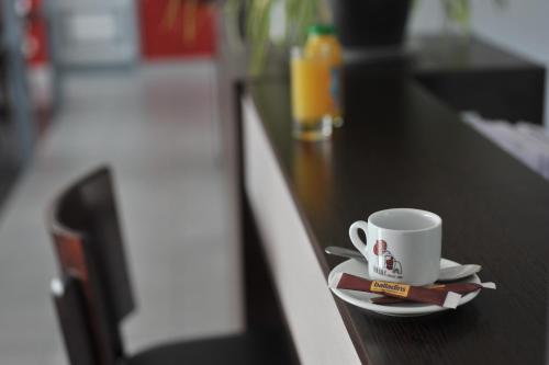 a coffee cup sitting on top of a counter at initial by balladins Roissy / Saint-Mard in Saint-Mard