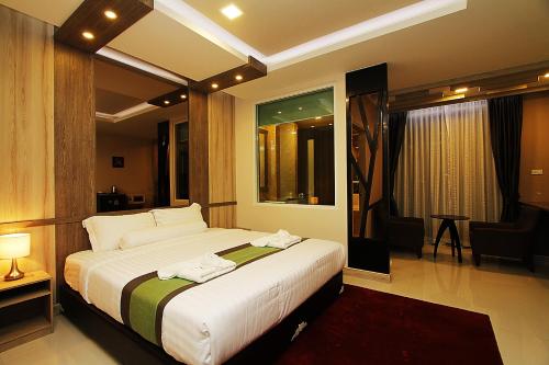 um quarto com uma cama grande num quarto em The Contrast i Hotel em Pluak Daeng