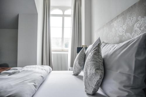 a bedroom with a bed with pillows and a window at Bad Schauenburg in Liestal