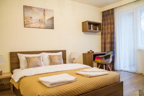 ein Schlafzimmer mit einem Bett mit zwei Handtüchern darauf in der Unterkunft Boem Studio in Braşov