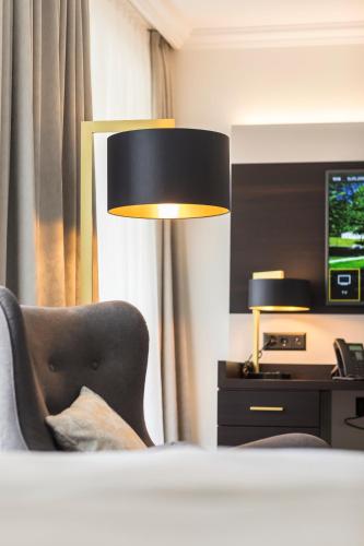a room with a bed and a chair and a television at Bad Schauenburg in Liestal