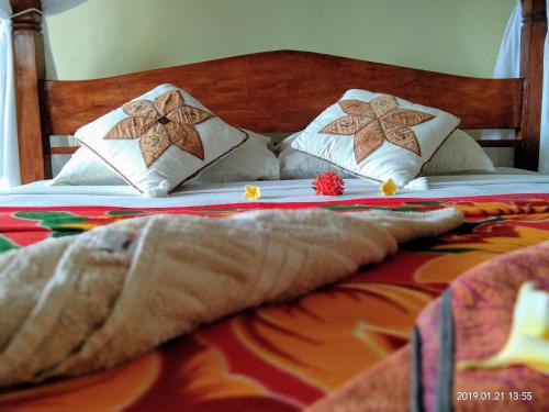 een bed met twee kussens erop bij Bukit Indah Homestay in Amed