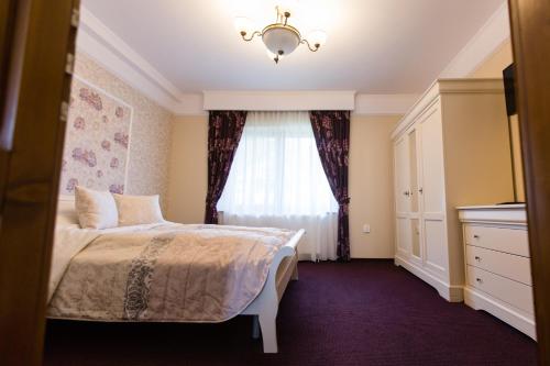 a bedroom with a bed and a window at Vila Anna in Malnaş Băi