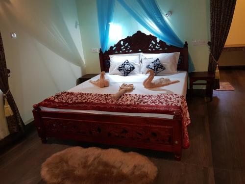 a bedroom with a bed with two dolls on it at Kerala cottage in Varkala