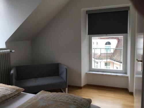 a bedroom with a bed and a chair and a window at Ferienwohnung Villa Josephine in Badenweiler