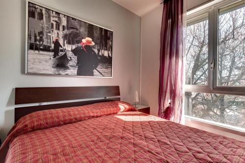 een slaapkamer met een bed en een groot raam bij Smart Mestre centre in Mestre