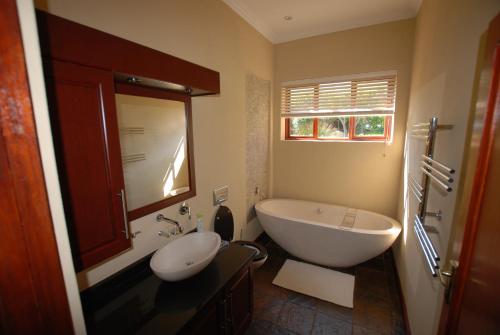 un bagno con vasca, lavandino e vasca da bagno di Kingsbury Cottage a Breërivier