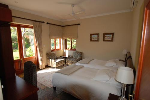 una camera da letto con un grande letto bianco in una stanza di Kingsbury Cottage a Breërivier