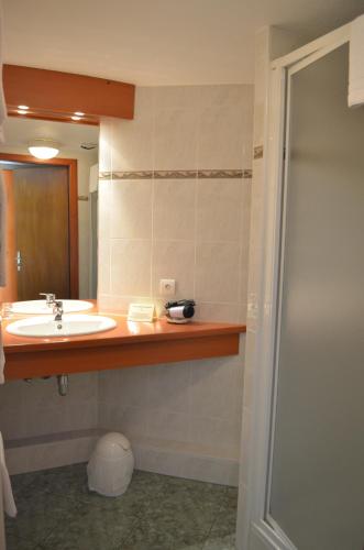 a bathroom with a sink and a mirror at Logis Hotel & Restaurant - Les Vosges in Dabo
