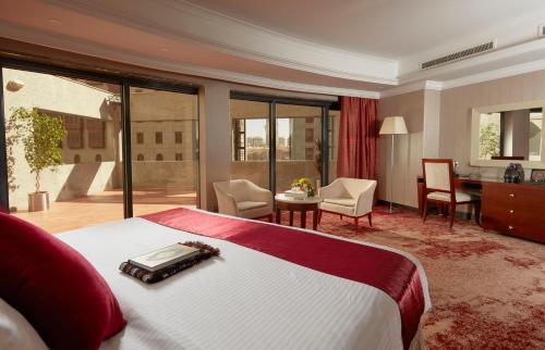 a hotel room with a bed and a desk and a room at Frontel Al Harithia Hotel in Al Madinah
