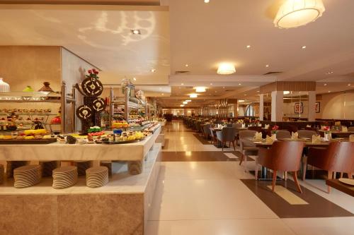ein Restaurant mit Tischen und Stühlen und einem Buffet in der Unterkunft Frontel Al Harithia Hotel in Medina