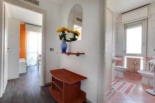 een badkamer met een toilet en een vaas met bloemen bij Smart Mestre centre in Mestre