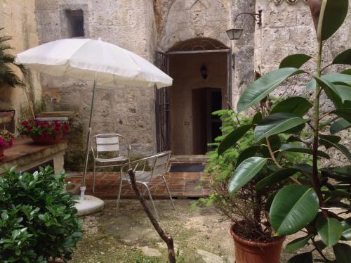 an umbrella and a chair in a courtyard at A Casa di Irene in Matera