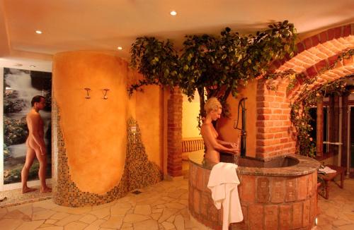 a woman standing next to a tub in a room at All Inclusive Hotel Bachmayerhof in Uderns