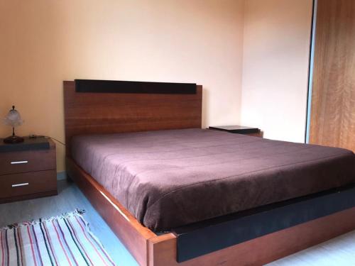a bedroom with a large bed with a wooden headboard at House on the Beach in Machico