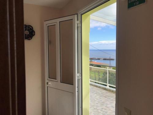 eine Tür zu einem Balkon mit Meerblick in der Unterkunft House on the Beach in Machico