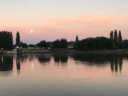 a view of a lake at sunset at La Seine en couleurs in Duclair