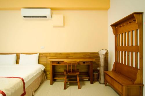 a bedroom with a bed and a desk with a chair at XinFu Traveler Inn in Taiping
