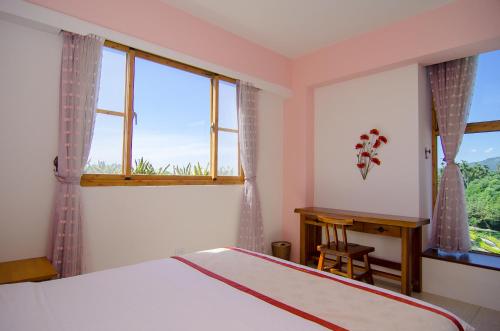 a bedroom with a bed and a window and a desk at XinFu Traveler Inn in Taiping