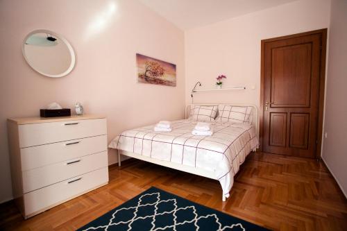 1 dormitorio con cama, tocador y espejo en New Stylish and Cozy House, en Tesalónica