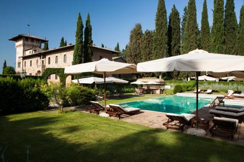 basen z parasolami i krzesłami oraz budynek w obiekcie Hotel La Collegiata w mieście San Gimignano