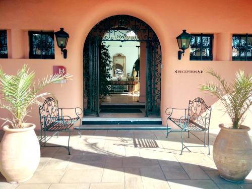 two benches sitting in front of a building at Hôtel Chantaco Golf & Wellness in Saint-Jean-de-Luz