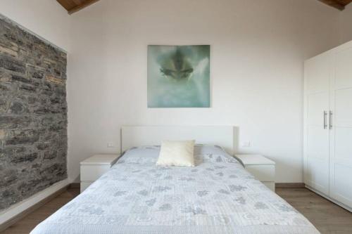 a bedroom with a bed and a brick wall at Lilia's Home in Cernobbio