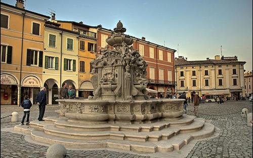 una fontana in una piazza in una città con edifici di RESIDENZA LEON D'ORO a Cesena