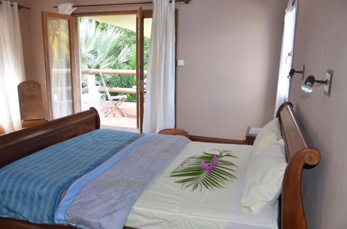 a bedroom with a bed with a flower on it at serin du cap in Blue Bay