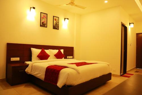 a bedroom with a large bed with red pillows at Palmtree Leaf, Munnar in Munnar