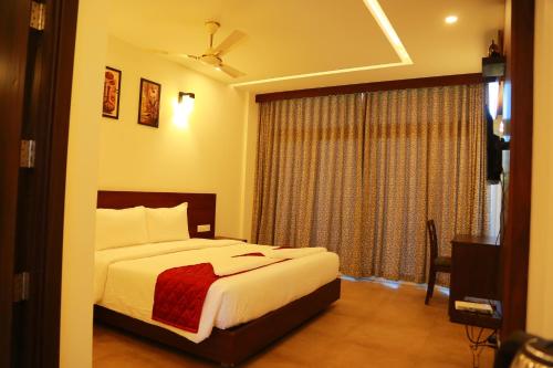 a hotel room with a bed and a window at Palmtree Leaf, Munnar in Munnar