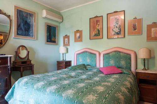 1 dormitorio con 1 cama y algunas fotos en la pared en Carly & Dane Vacation House, en Taormina
