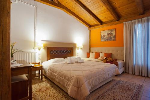 a bedroom with a large bed and a desk at Pan Hotel in Delfoi