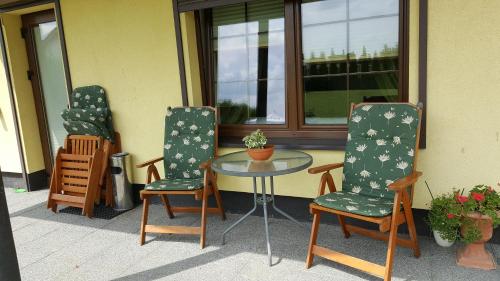 three chairs and a glass table on a patio at Villa Sole in Pruszcz Gdański
