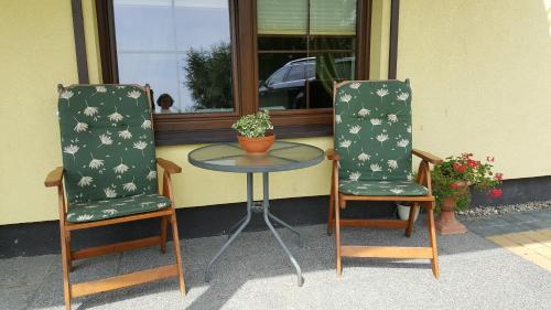 two chairs and a table in front of a window at Villa Sole in Pruszcz Gdański