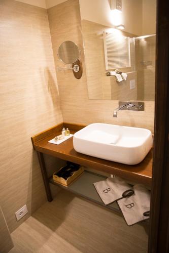 a bathroom with a white sink and a mirror at Locanda Bepa in Ostiglia